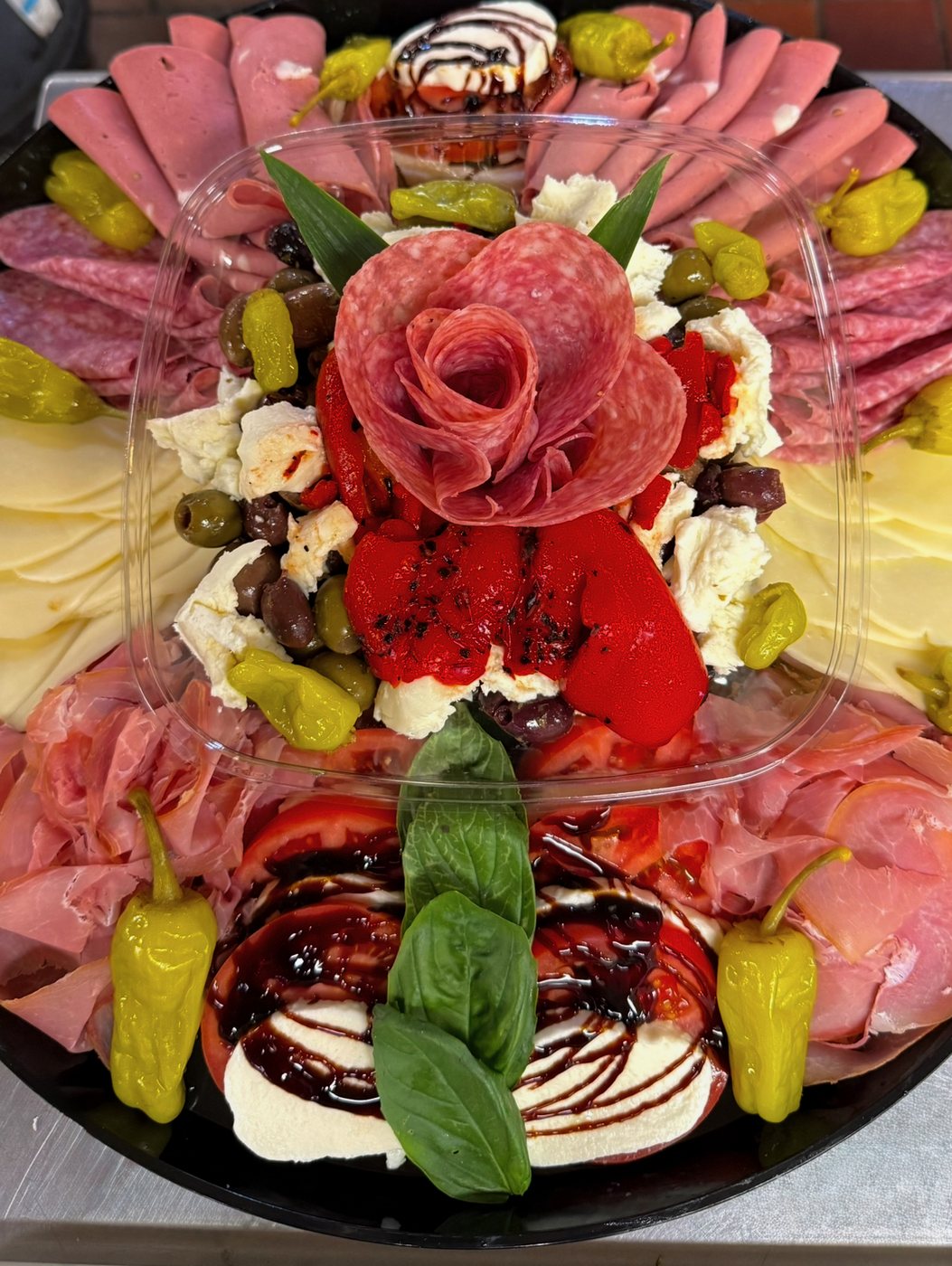 Antipasto platter with a salami rose, fresh mozzarella, roasted peppers and olives