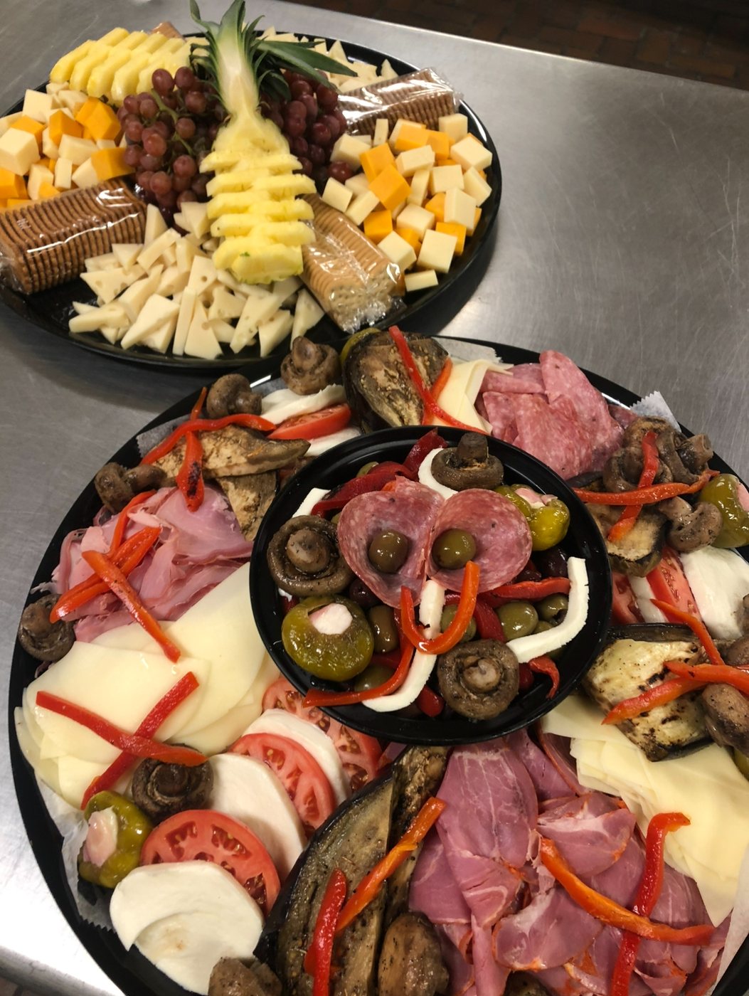 Cheese and fruit platter beside an antipasto platter