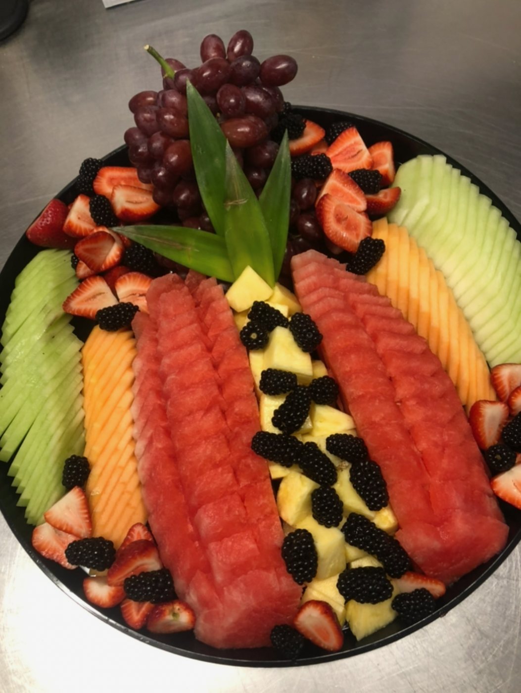 Fresh fruit platter with watermelon, melon, pineapple, berries and grapes
