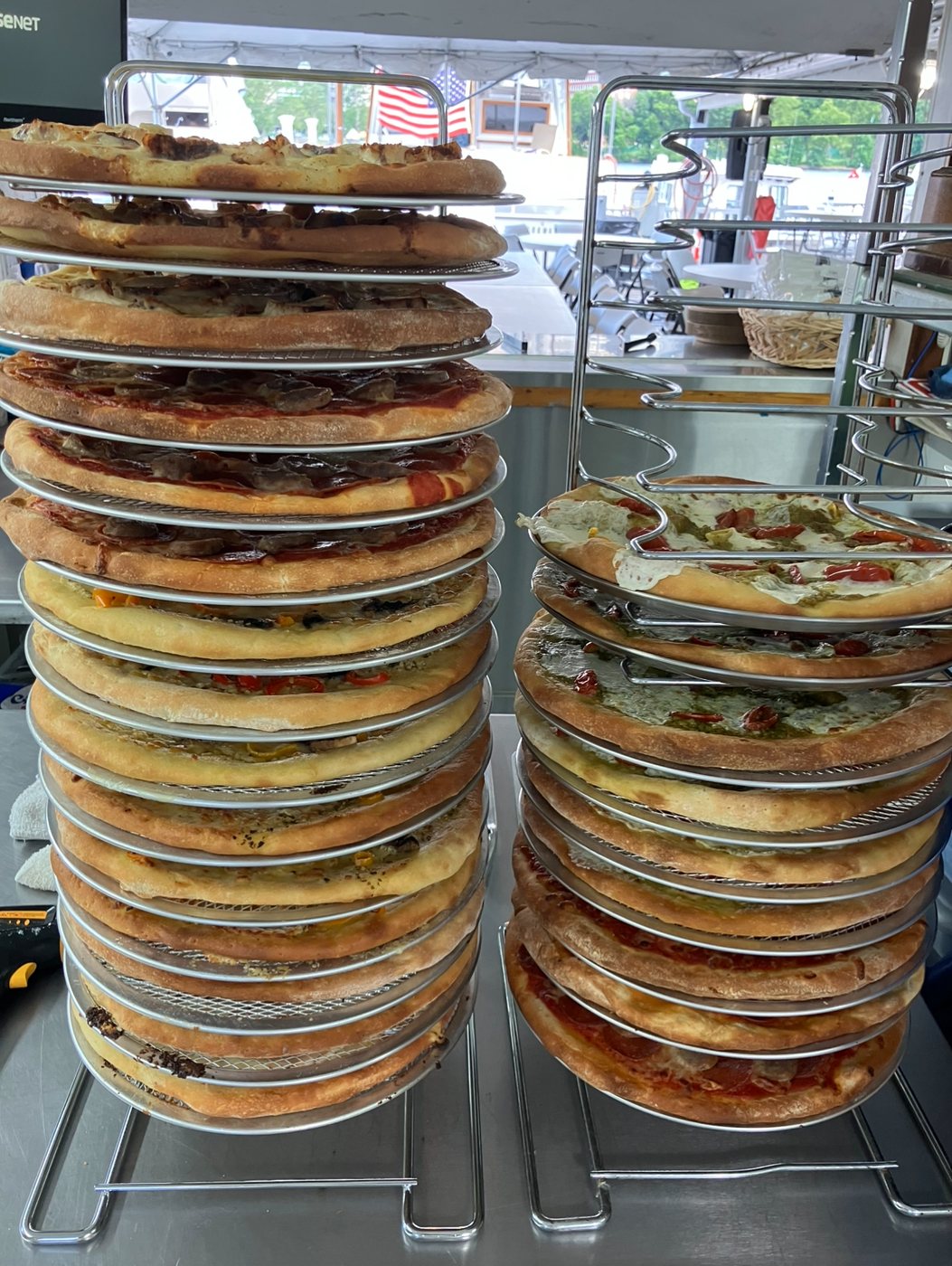 Racks stacked with fresh pizzas at an event