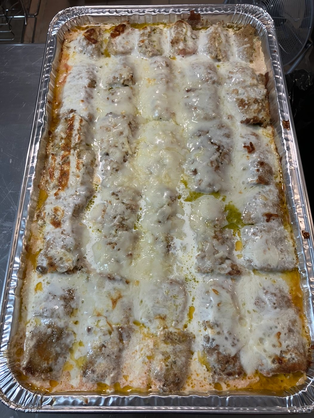 Full tray of a baked entrée topped with melted mozzarella