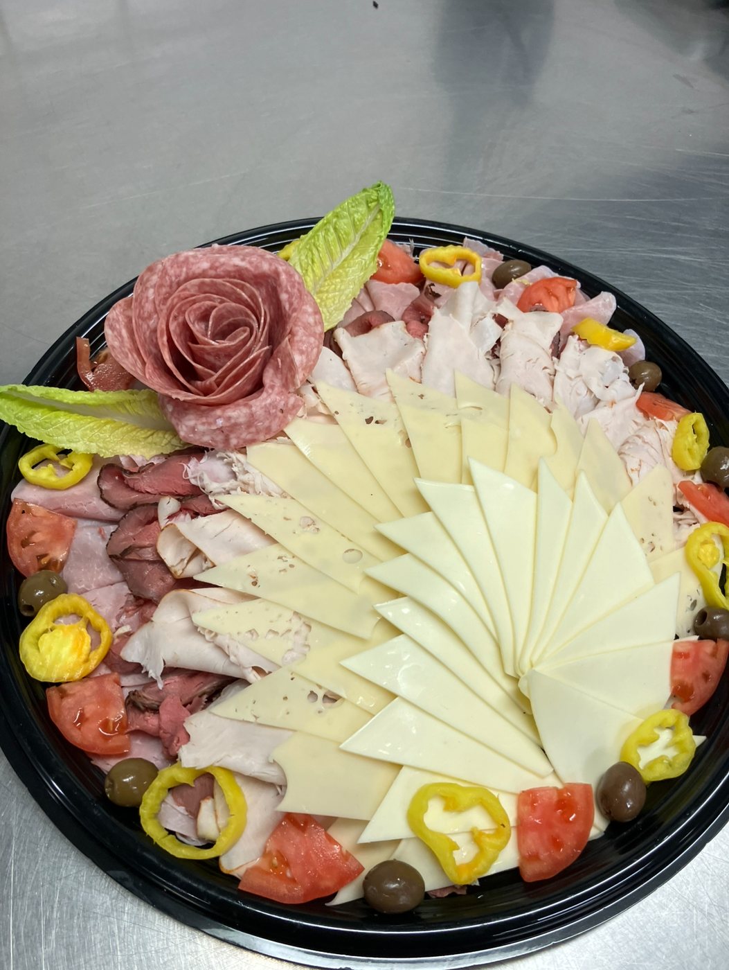 Deli platter with a salami rose and fanned cheeses
